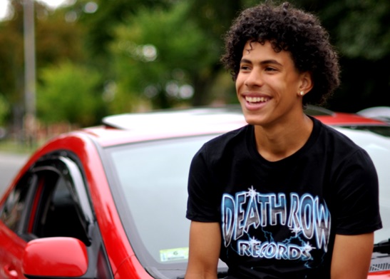 Smiling man standing next to car