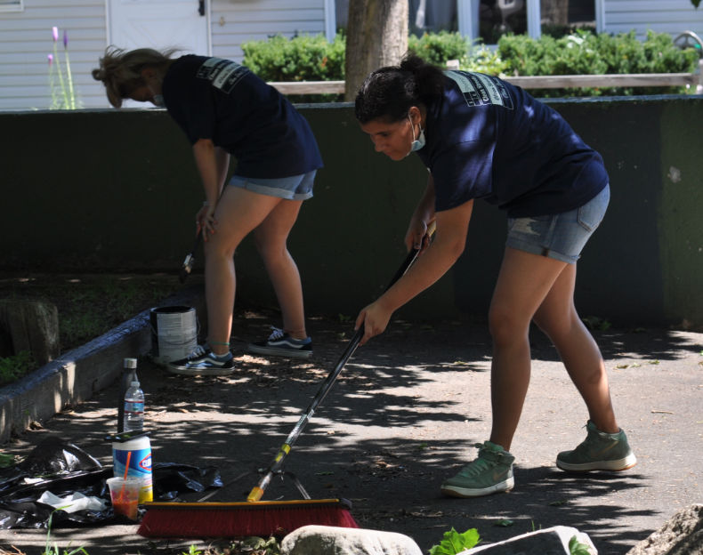 women cleaning up parking lot area