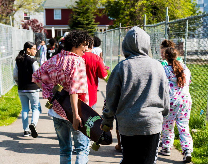 Group of teens walking on a sidewalk